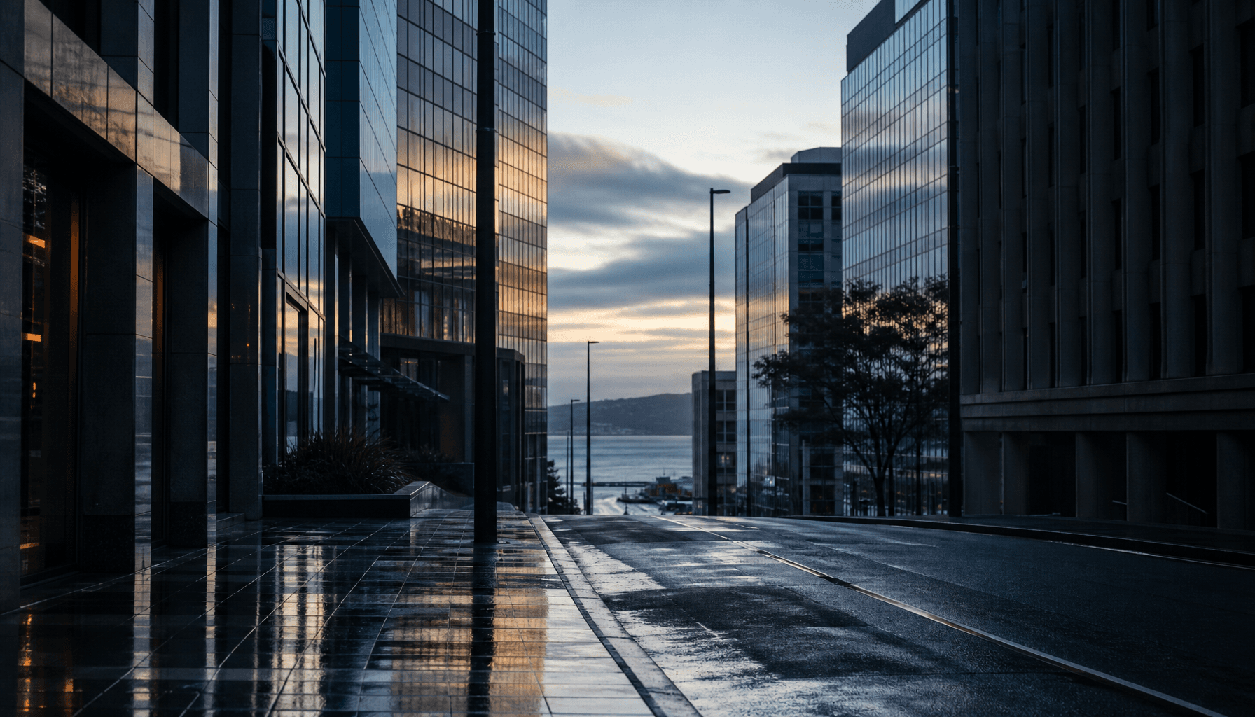 Wellington's Lambton Quay banking precinct at dawn, glass towers reflecting early light toward the harbour